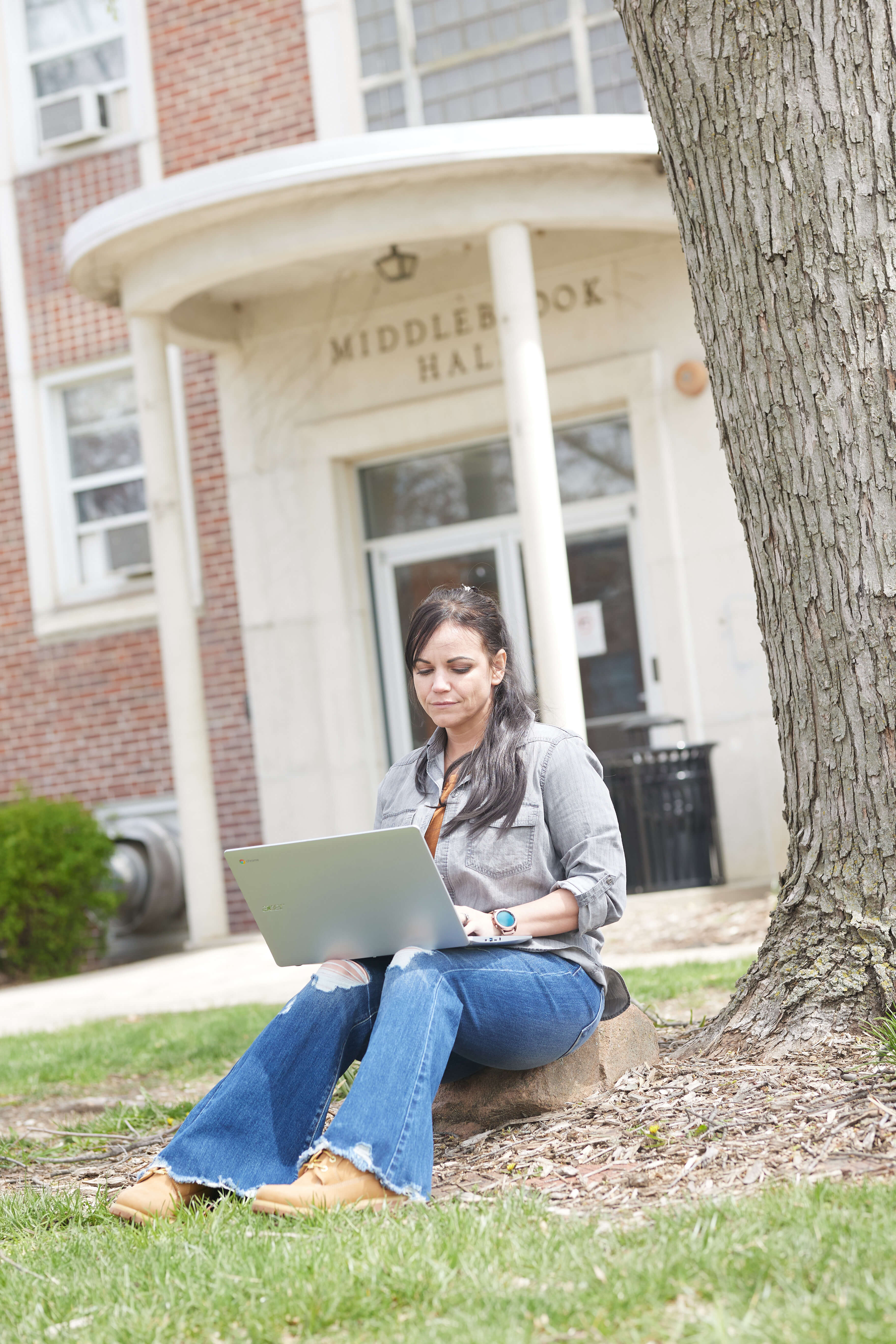 woman typing on laptop outside